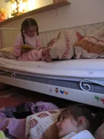 Poesje en zusje worden voorgelezen..